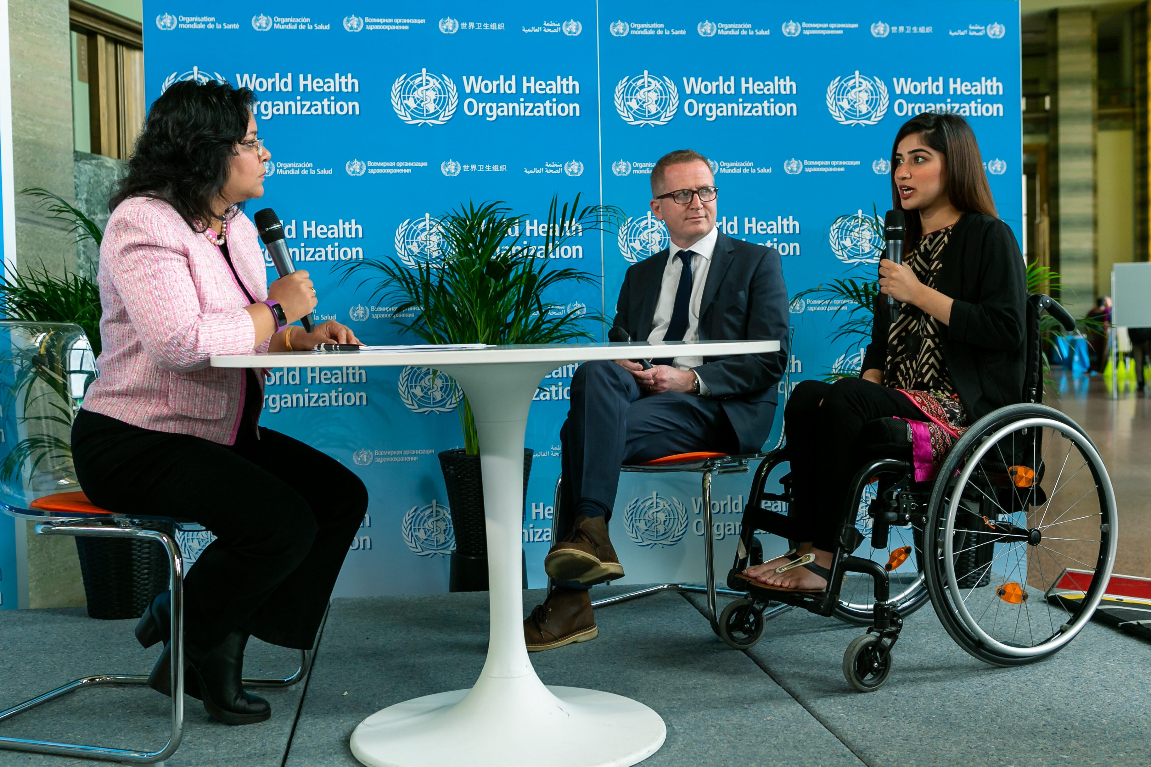 A young woman in wheel chair speaking into microphone